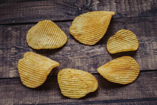 Хрусткі картопляні чіпси на дерев'яному фоні. запущено чипи — стокове фото