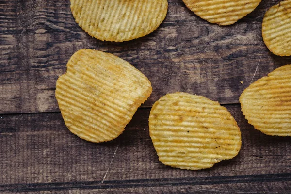 crispy potato chips on wooden background. chips started