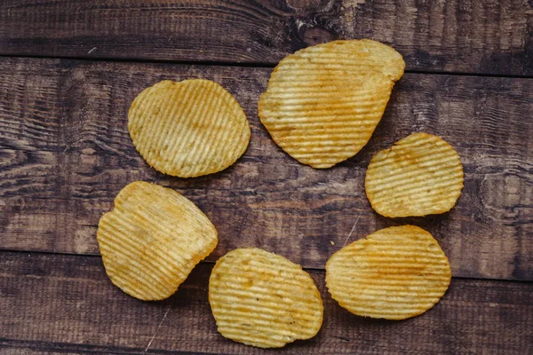 Papas fritas crujientes sobre fondo de madera. chips comenzaron — Foto de Stock