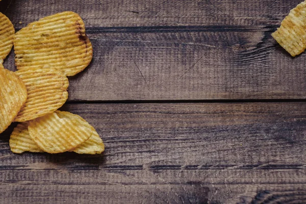 Papas fritas crujientes sobre fondo de madera. chips comenzaron — Foto de Stock