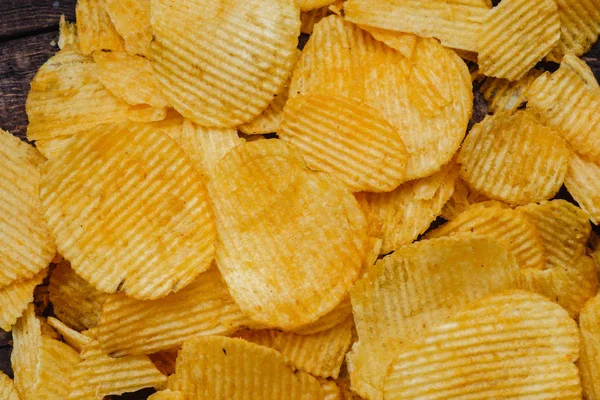 Papas fritas crujientes sobre fondo de madera. chips comenzaron — Foto de Stock