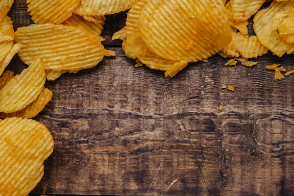 Papas fritas crujientes sobre fondo de madera. chips comenzaron — Foto de Stock