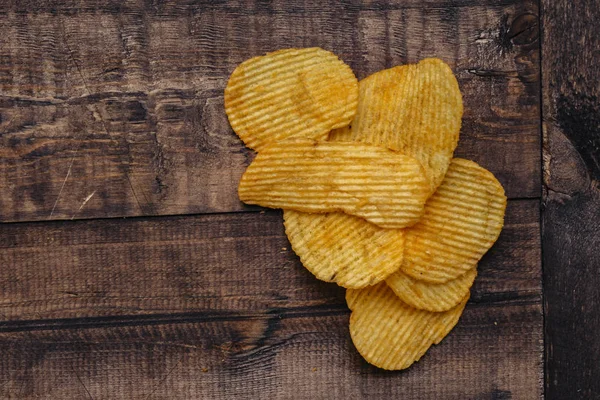 Patatine croccanti su sfondo di legno. chip avviati — Foto Stock