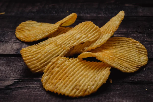 Papas fritas crujientes sobre fondo de madera. chips comenzaron — Foto de Stock