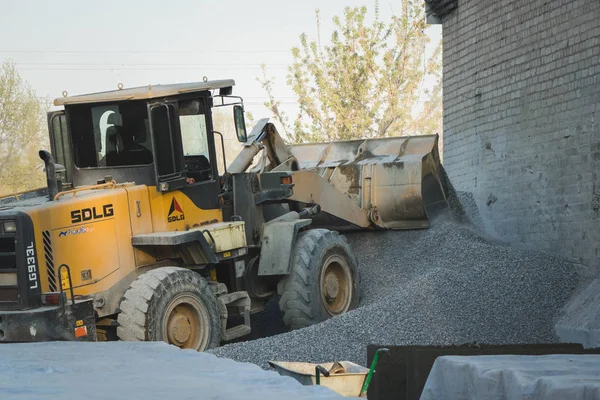 Voronezh region, russland, 25. april 2019. traktorladungen schotter bei der produktion von beton. Ein gelber Traktorlader fährt in Schutthaufen. Schaufel lädt den Beton. — Stockfoto