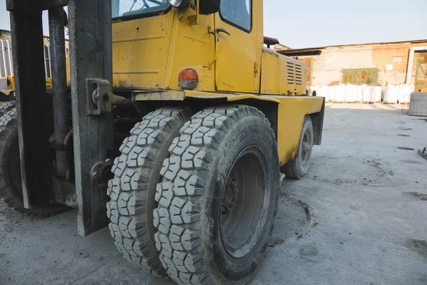 Stock image big spiked wheels of yellow tractor durable rubber tires