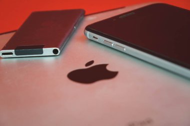 Moskova, Rusya - 25 Nisan 2019: ipod, iphone ve ipad arka arkaya yatıyor . Kırmızı arka planda üretim. elma ürünleri. Yapımcı: Apple Inc..