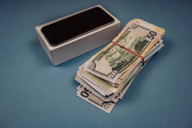 Mavi monofonik arka planda Apple iphone cihazları ve dolar. Voronej, Rusya - 3 Mayıs 2019