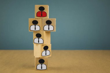 wooden cubes in the form of bosses and subordinates, personnel subordination on a blue background