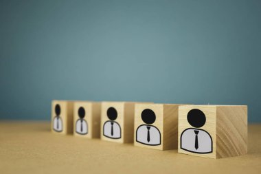 Sıraya dizilmiş ahşap küpler, yani maaş işçileri tek sıra halinde, mavi arka planda soyutlama.