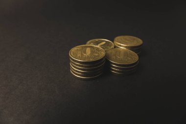 siyah bir arka plan üzerinde üst üste yatan birçok altın sikke