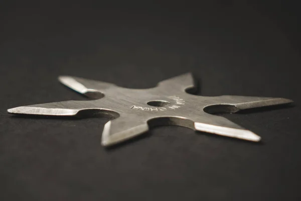 Silver shuriken on a black background, throwing weapons — Stock Photo, Image