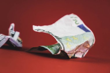 kırmızı bir arka plan üzerinde yatan yüz euro ve dolar buruşuk fatura