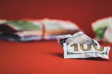 ön planda yatan ve kırmızı bir arka plan üzerinde nakit bir demet arkasında buruşuk fatura