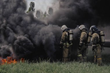 4 kişi miktarında tam koruma ekipmanı giyen cesur itfaiyeciler sis perdesi geçti.