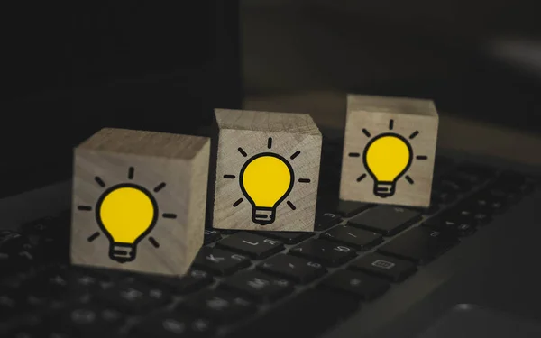 Houten blokjes met lampen op laptop toetsenbord. Nieuwe concepten voor idee, innovatie en oplossing. — Stockfoto