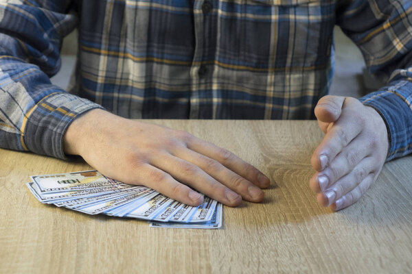Мужчина считает деньги в руке. Финансы, сбережения, зарплата и пожертвования
.