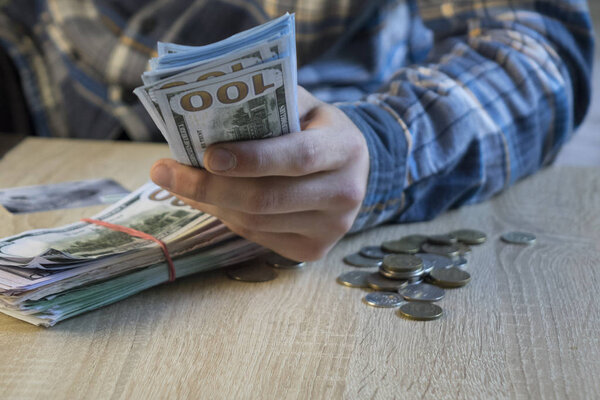 Мужчина считает деньги в руке. Финансы, сбережения, зарплата и пожертвования
.