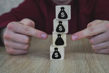 Para torbaları şeklinde 5 ahşap küpler. El bir çanta seçer.