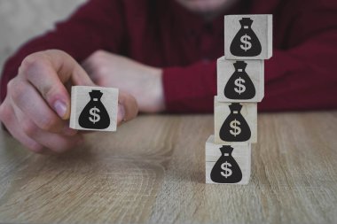 Para torbaları şeklinde 5 ahşap küpler. El bir çanta seçer.