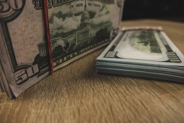 ahşap bir arka plan üzerinde bir lastik bant ile bağlı amerikan doları bir demet.