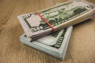 ahşap bir arka plan üzerinde bir lastik bant ile bağlı amerikan doları bir demet.