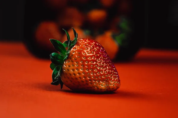 Fresas frescas y jugosas con hojas. Fresa sobre fondo rojo — Foto de Stock