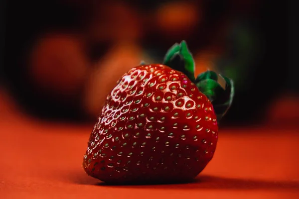 Frische saftige Erdbeeren mit Blättern. Erdbeere auf rotem Hintergrund — Stockfoto