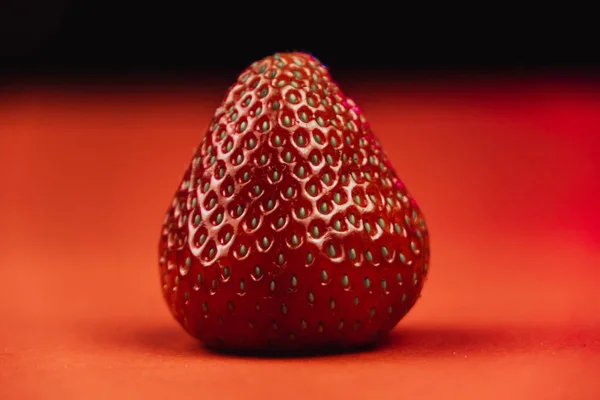 Frische saftige Erdbeeren mit Blättern. Erdbeere auf rotem Hintergrund — Stockfoto