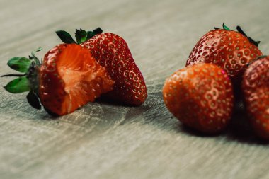 Beyaz ahşap arka plan üzerinde kase taze çilek yığını.