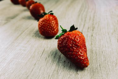 Olgun çilek tahta yüzeyi satırı. Mevsimlik bir kahvaltı olarak satırlardaki organik tatlı çilek. Bir çiftlik taze.