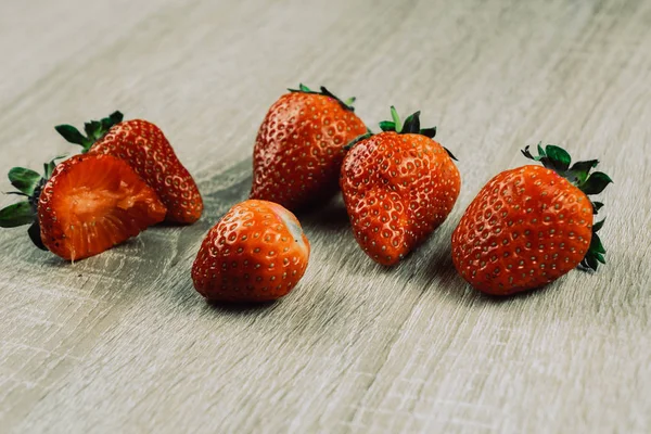 Montón de fresas frescas en un tazón sobre fondo de madera blanca . — Foto de Stock