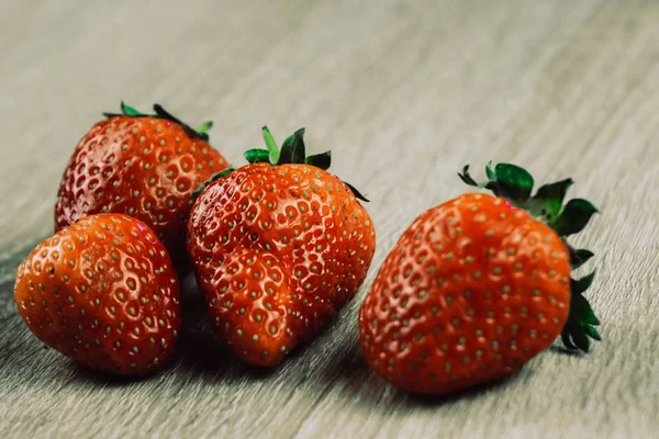 Haufen frischer Erdbeeren in Schale auf weißem Holzhintergrund. — Stockfoto