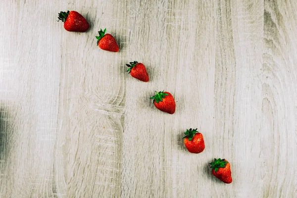 Olgun çilek tahta yüzeyi satırı. Mevsimlik bir kahvaltı olarak satırlardaki organik tatlı çilek. Bir çiftlik taze.