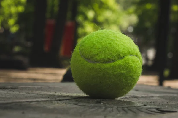 Gele tennisbal met een racket op de baan — Stockfoto