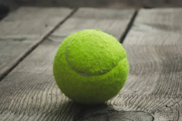 Gele tennisbal met een racket op de baan — Stockfoto