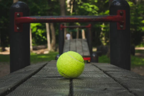 Pelota de tenis amarilla con raqueta en la pista de calle — Foto de Stock