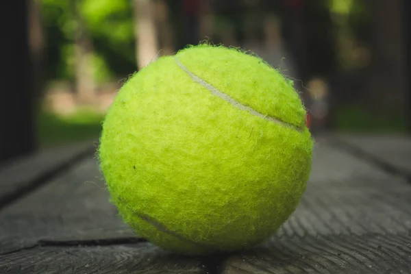 Gele tennisbal met een racket op de baan — Stockfoto