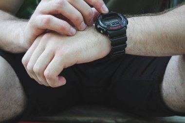 adam sportif siyah bir saat bir düğmeye basar.