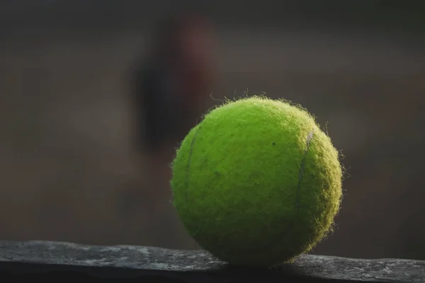 Pelota de tenis acostado en un soporte de metal — Foto de Stock