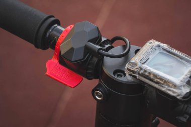 siyah elektrikli scooter parkta lastik ped üzerinde duran, direksiyon görünümü.