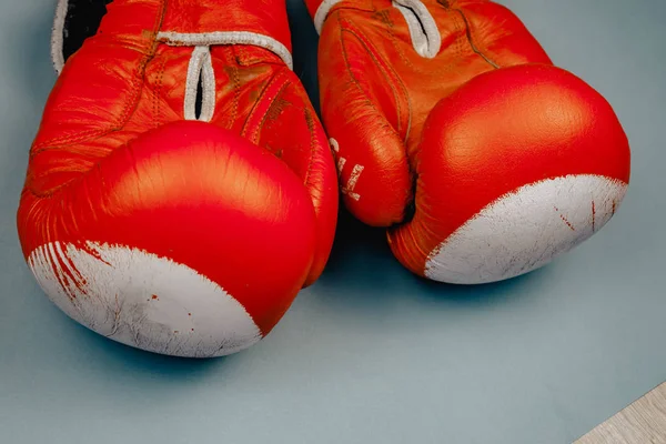 Rode verschoten bokshandschoenen op blauwe achtergrond — Stockfoto