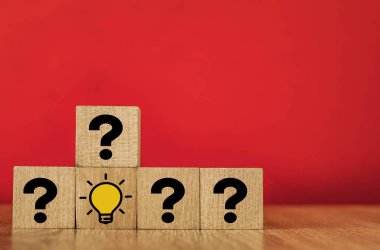 İşaretli ve ampullü tahta küp. Ampul bir fikri simgeler. kırmızı arkaplanda.