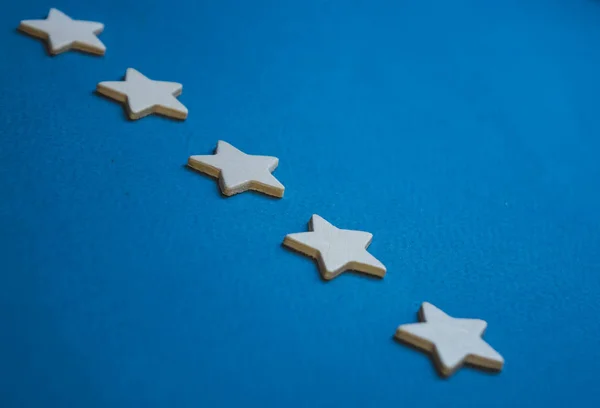 Ξύλινοι κύβοι με τη μορφή αστεριών τοποθετημένοι σε μια σειρά σε μπλε φόντο — Φωτογραφία Αρχείου