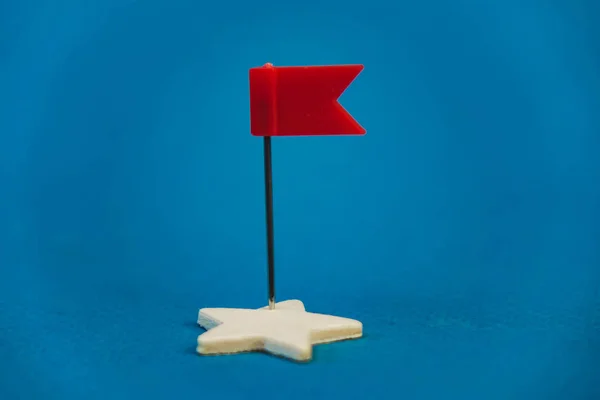 Étoiles en bois et une rouge sur fond bleu avec un drapeau rouge — Photo