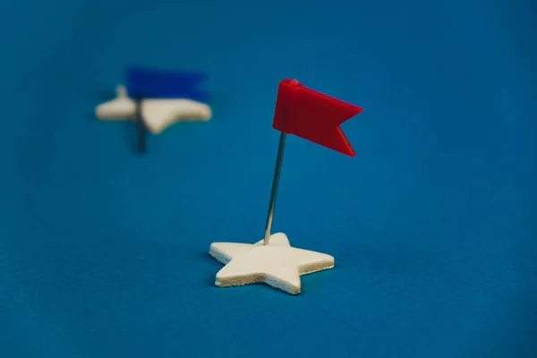 Étoiles en bois et une rouge sur fond bleu avec un drapeau rouge — Photo