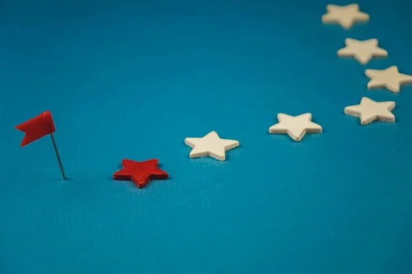 Ξύλινα αστέρια και ένα κόκκινο σε μπλε φόντο με κόκκινη σημαία — Φωτογραφία Αρχείου