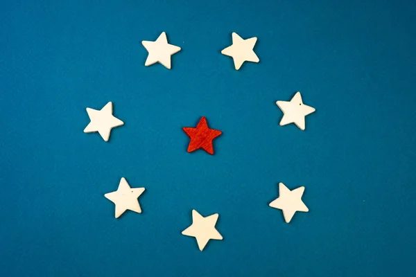 Egy csomó fából készült csillagok, és egyikük pirossal jelölve. figyelemmel a kék háttér. — Stock Fotó