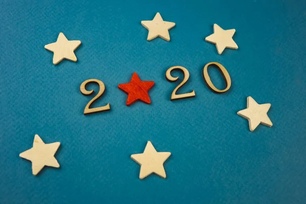 2020-Zahl aus Holzzahlen auf blauem Hintergrund mit verstreuten Sternen und Flaggen — Stockfoto
