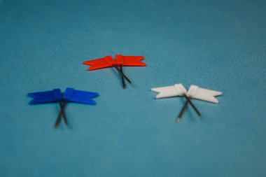 Mavi arka plan üzerinde kırmızı mavi ve beyaz üst üste yatan 2 bayrak.